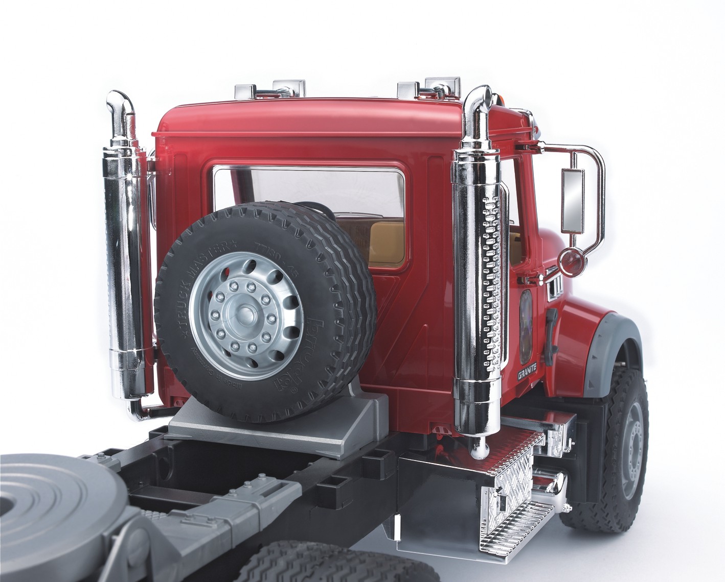 Camión MACK Granite con plataforma baja y JCB 4CX
